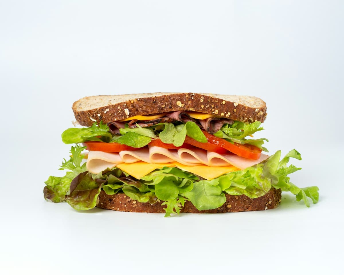 Sandwich de pan integral con jamón, queso, tomate y lechuga